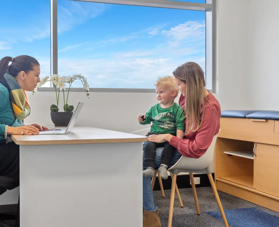 A paediatrician talking with a mother and her son